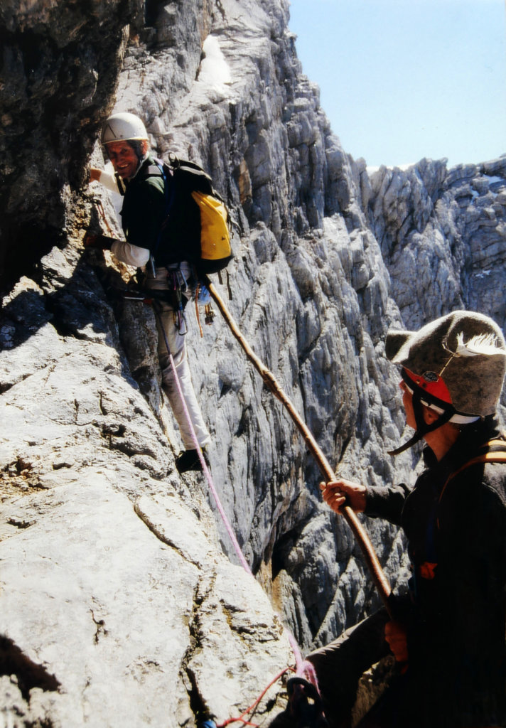 Abb. 1: Der damals 73-jährige Franz Pilz „hilft“ Bergführer Klaus Hoi in der Schlüsselstelle des Steinerweges durch die Dachstein Südwand mit einem Stockschub ganz im Stil der Erstbegeher. Foto: Fritz Veitsberger